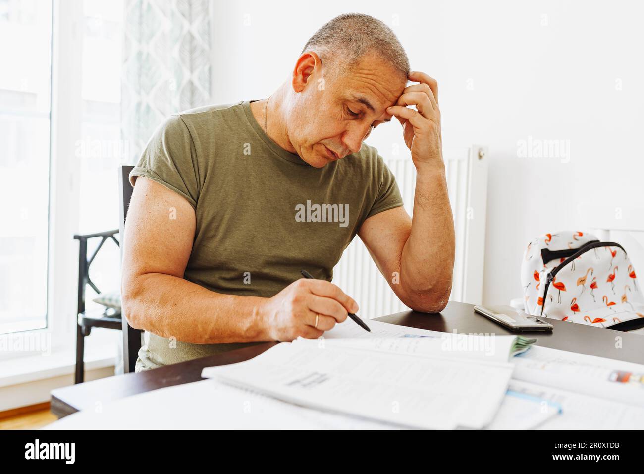 middle-aged man writes notes in notebook Stock Photo