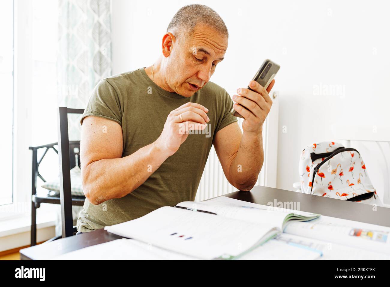 middle-aged man writes notes in notebook Stock Photo