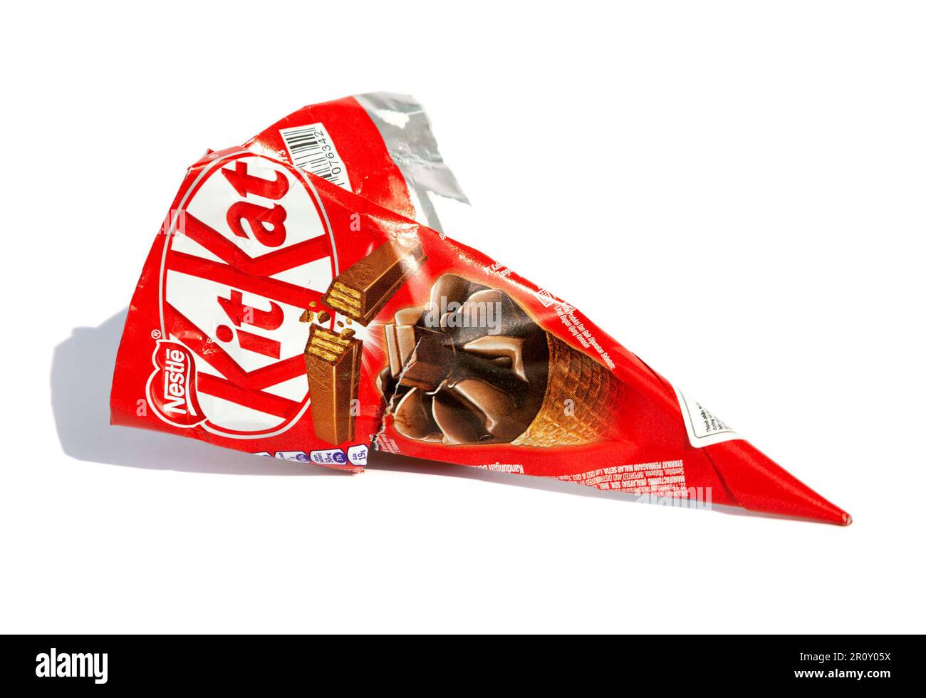 Ho Chi Minh City, Vietnam - May 10, 2023: KitKat cone ice cream torn wrapper isolated on white. Popular dessert red packaging with a brand logo discar Stock Photo