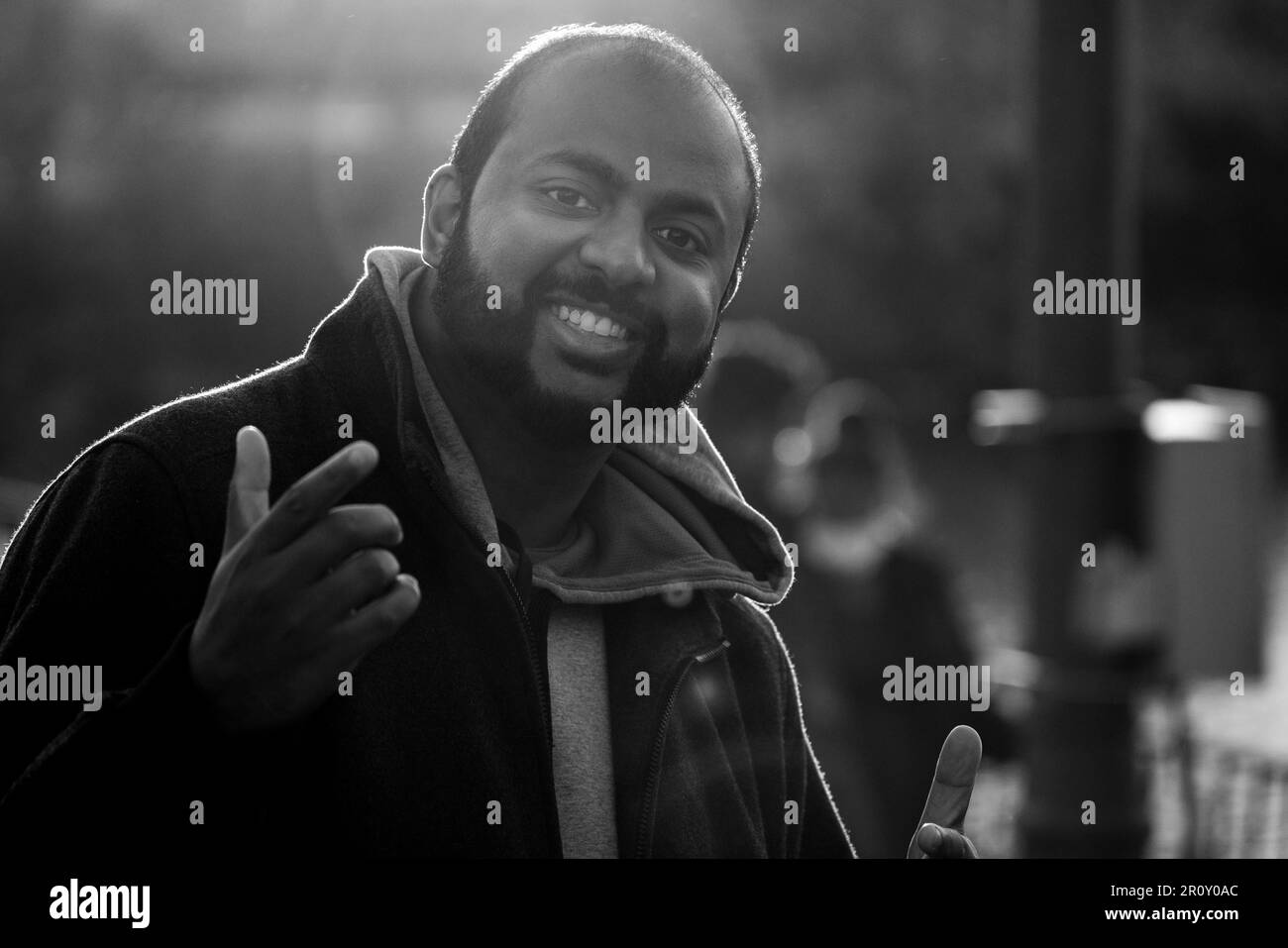 Happy South Asian Tamil man smiling and posing for a photo outdoors with his arms out in Brampton, Ontario Canada. Stock Photo