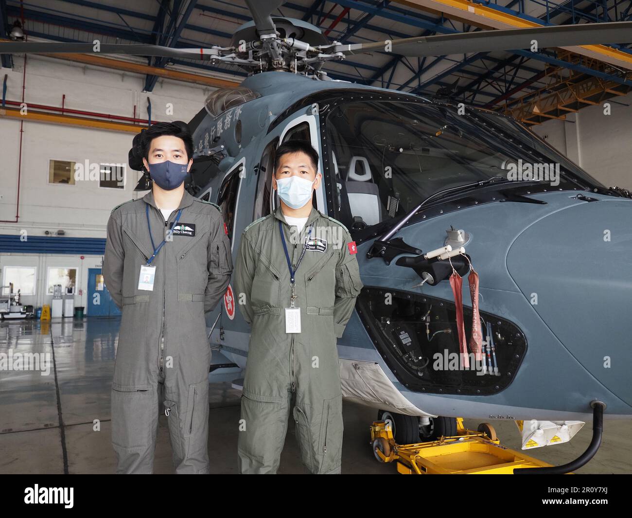 Pilot Billy Cheung Wing-kin (L) and winchman Cyrus Szeto Chi-pang with an airbus helicopter at the Government Flying Services in Hong Kong, November 26, 2022.  Credit: Martin Williams Stock Photo