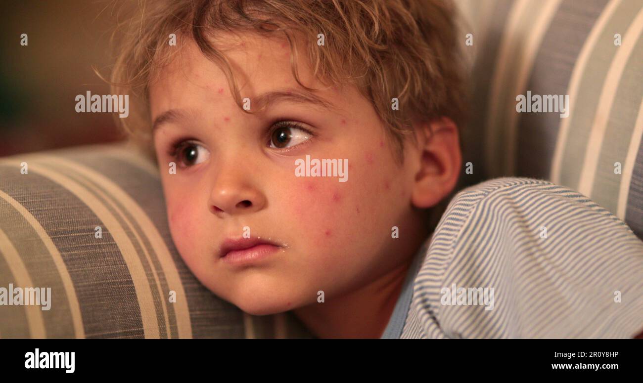 Baby toddler face watching TV screen at night on sofa at ngiht before