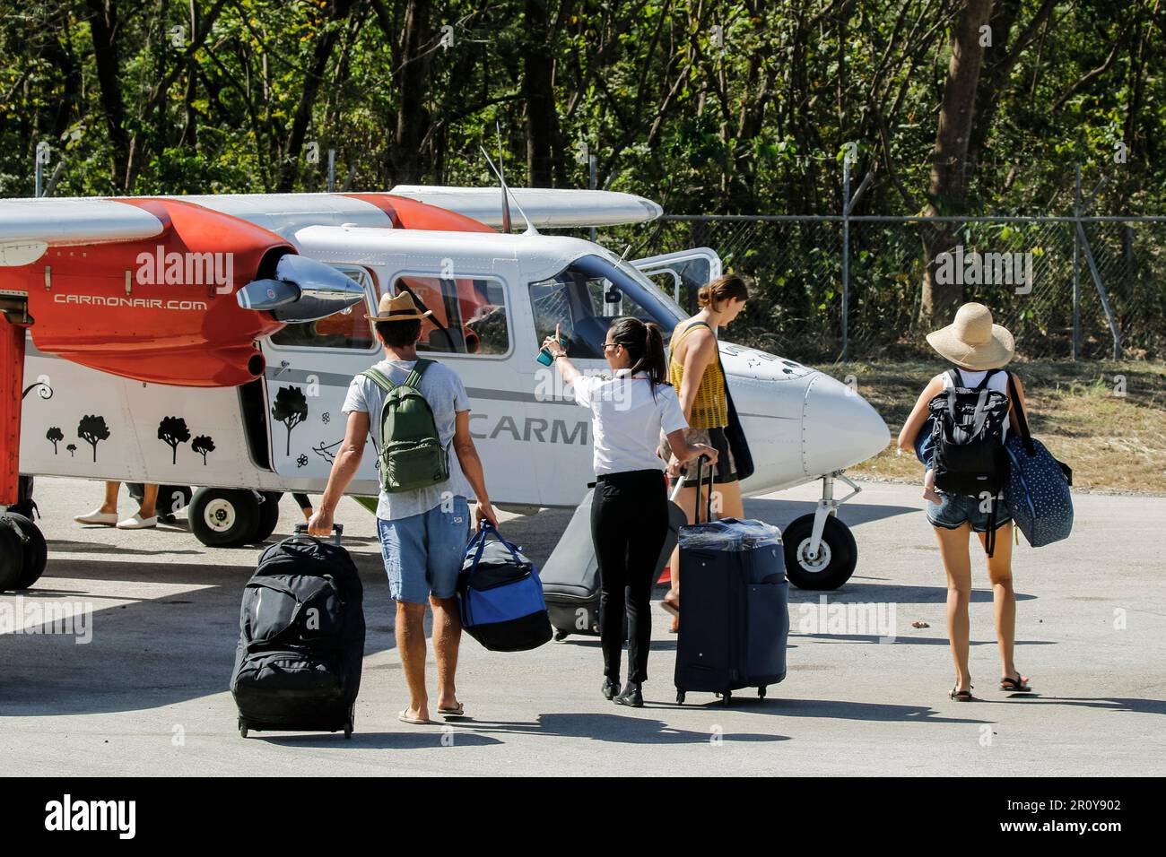 Passengers & crew take luggage to BrittenNorman Islander light plane