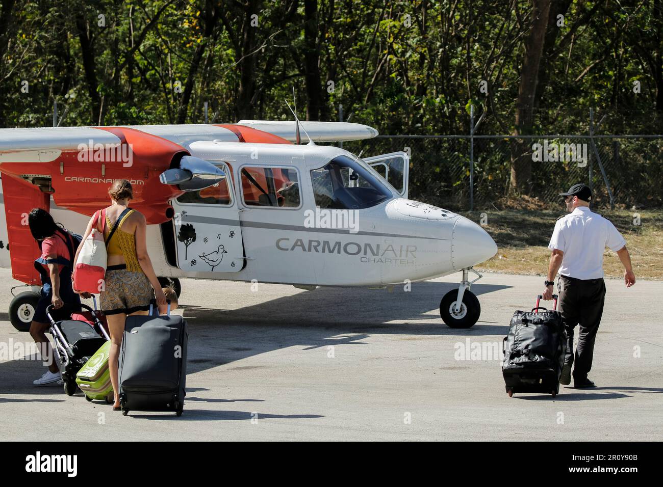 Passengers & crew take luggage to BrittenNorman Islander light plane