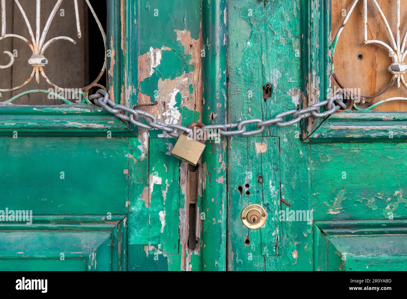 Close up view of old green painted double doors with paint peeling and