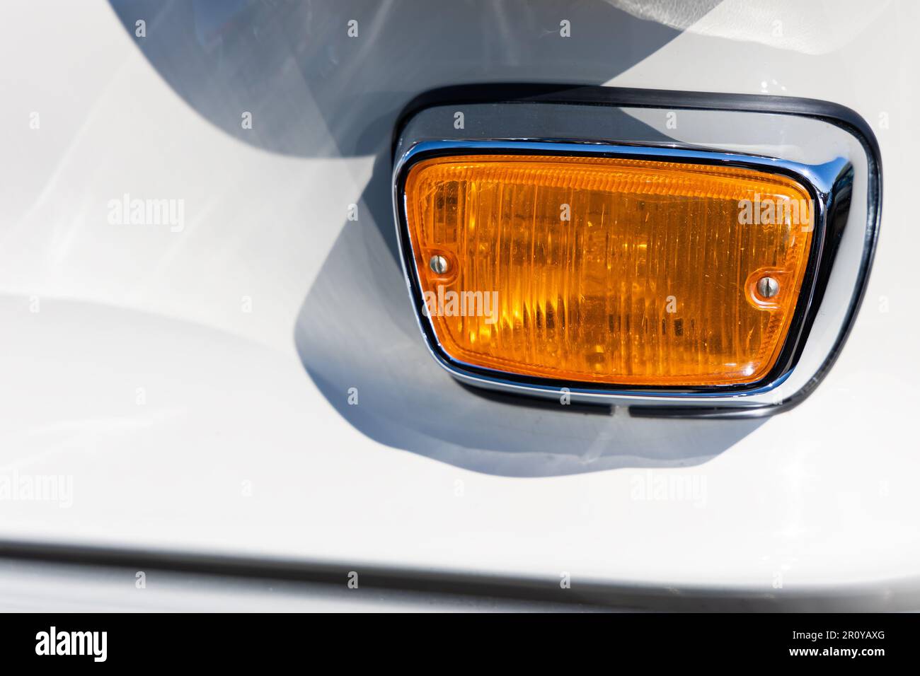 Closeup of the round turn indicator lights of a white classic car