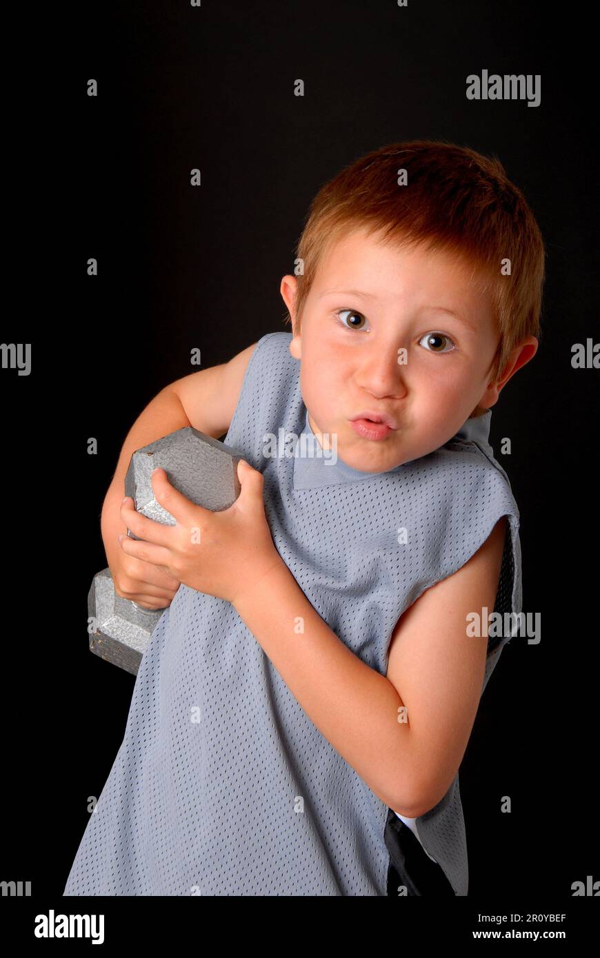 Young boy lifting weight that is too heavy Stock Photo Alamy