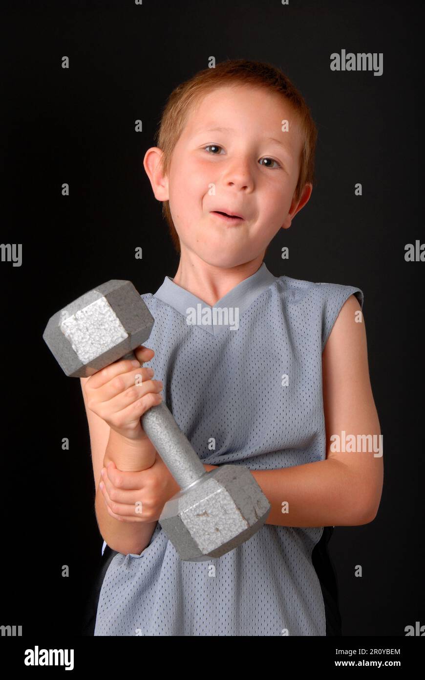 Young boy lifting weight that is too heavy Stock Photo Alamy