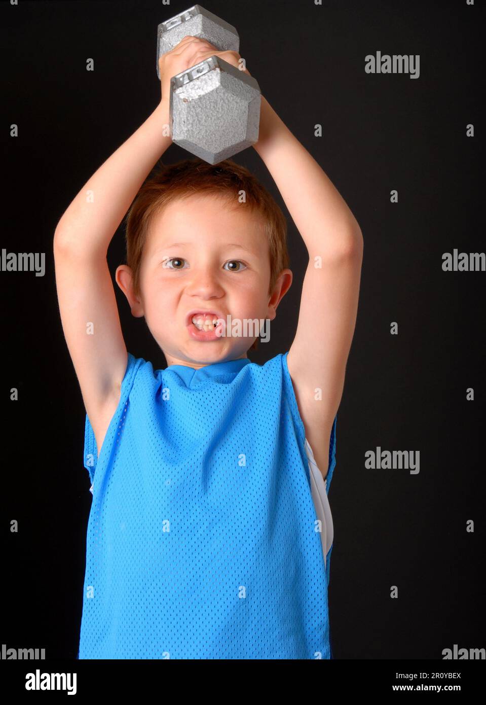 Young boy lifting weight that is too heavy Stock Photo Alamy