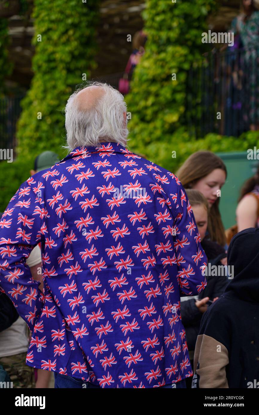 A senior man in a blue coat adorned with tiny Union Jack flags enjoyed the King Charles Coronation at the Valley Gardens in Harrogate, UK. Stock Photo