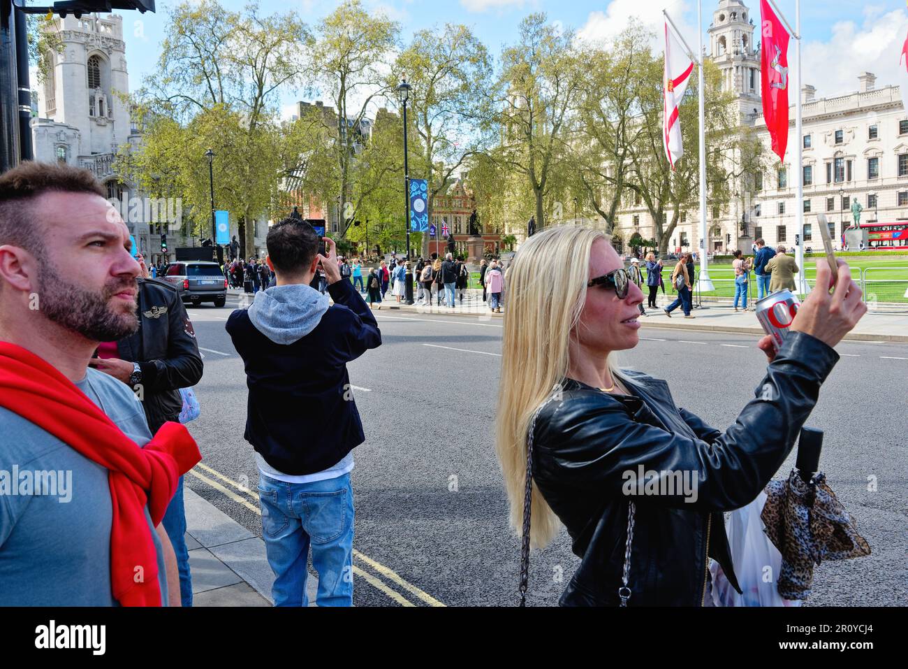 Tourists taking photographs in Parliament Square Westminster Central London on a sunny spring day, England Great Britain UK Stock Photo