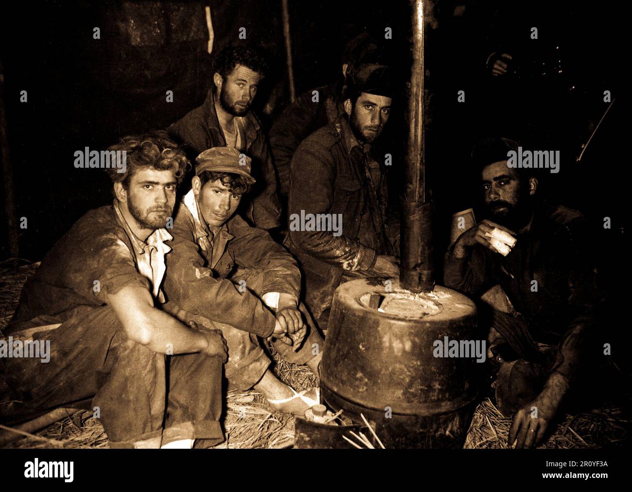 Former American and Australian prisoners of war warming up before a stove in the 24th Division medical clearing station after being returned to U.S. lines by Chinese Communists, February 10, 1951.  Photo by Sfc. Al Chang. (Army) Stock Photo