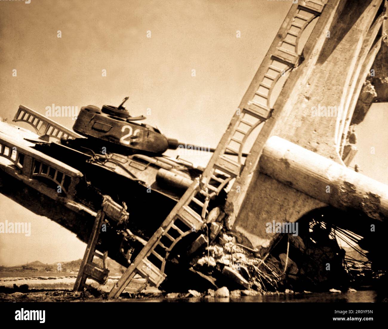 The wreckage of a bridge and North Korean Communist tank south of Suwon, Korea.  The tank was caught on a bridge and put out of action by the Air Force.  October 7, 1950. Stock Photo