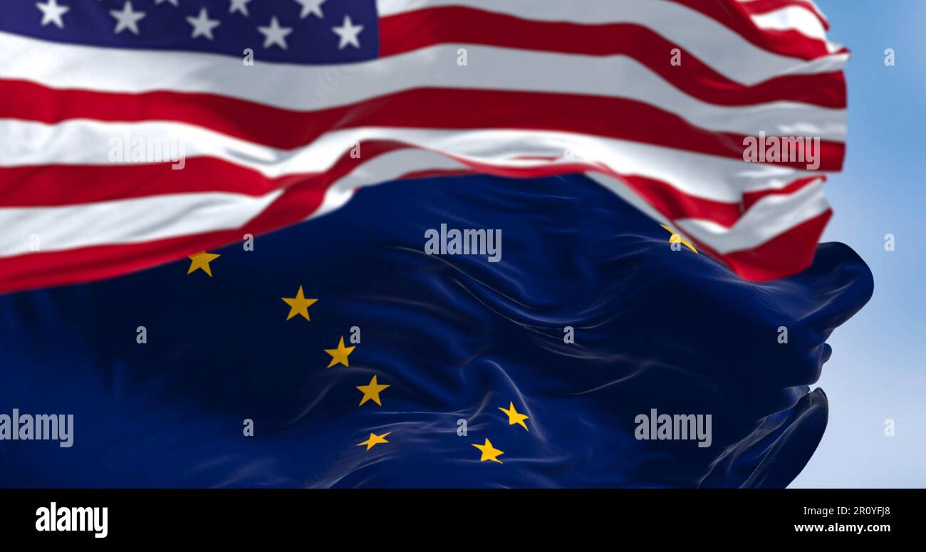Alaska state flag waving in the wind behind the national flag of the United States. Alaska flag is blue with Big Dipper and Polaris stars. Stock Photo