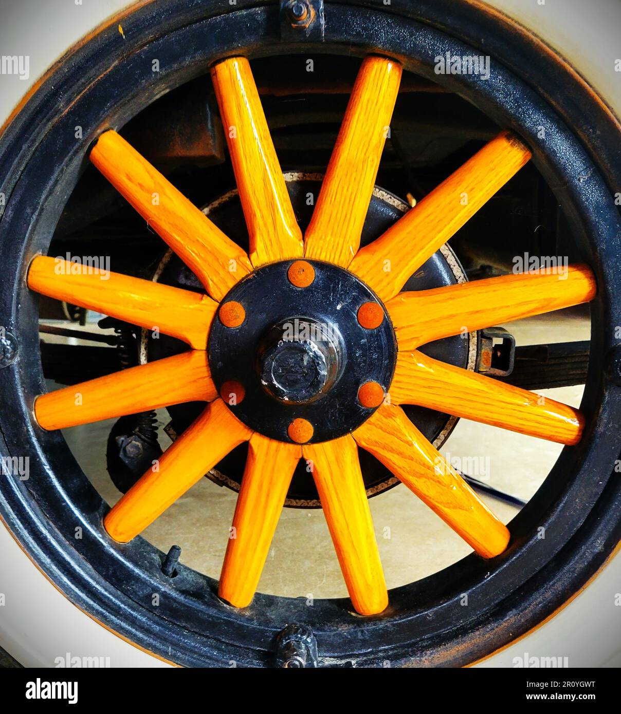 The bright yellow spokes on the wheel of this antique car really make