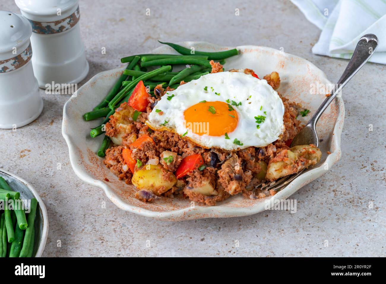 Corned beef hash with fried egg and green beans Stock Photo Alamy