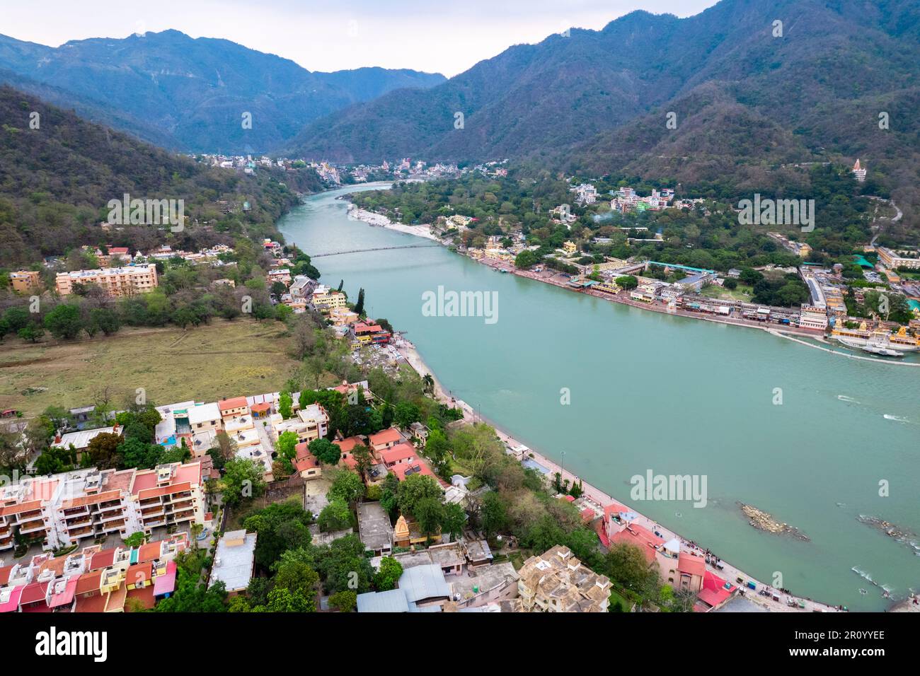 aerial drone shot over ram setu jhula suspension bridge with temples on the bank of river ganga in the holy spiritual city of Rishikesh Haridwar Stock Photo