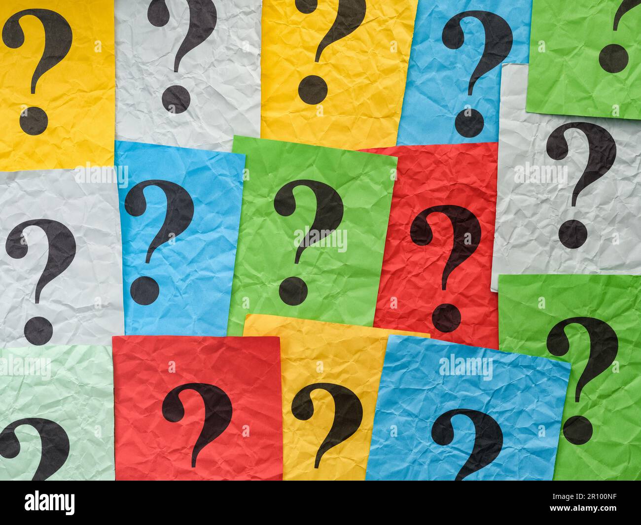 Crumpled colorful paper notes with question marks. Close up. Stock Photo