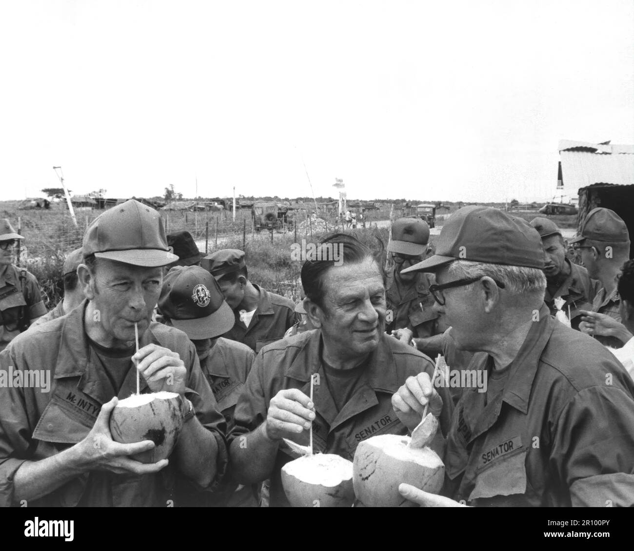 Pausing for refreshments during their visit to Huu Thanh, a recently pacified village, three U.S. Senators on President Nixon's fact-finding committee drink from local coconuts.  Sen. Thomas J. McIntyre, Sen. Howard Cannon, and Sen. George Murphy.  Circa 1970. Stock Photo