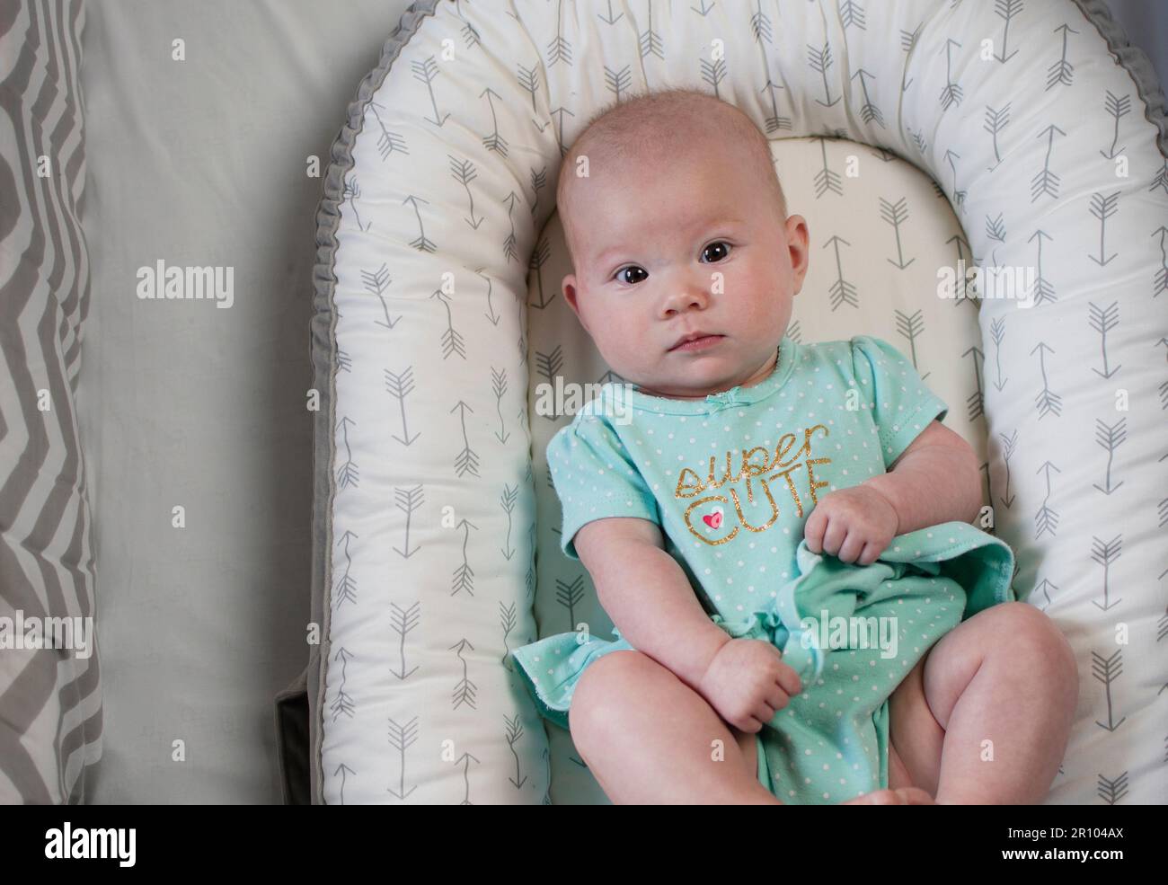 4 months old Caucasian cute baby girl in a crib. Infant girl. Newborn baby. Stock Photo