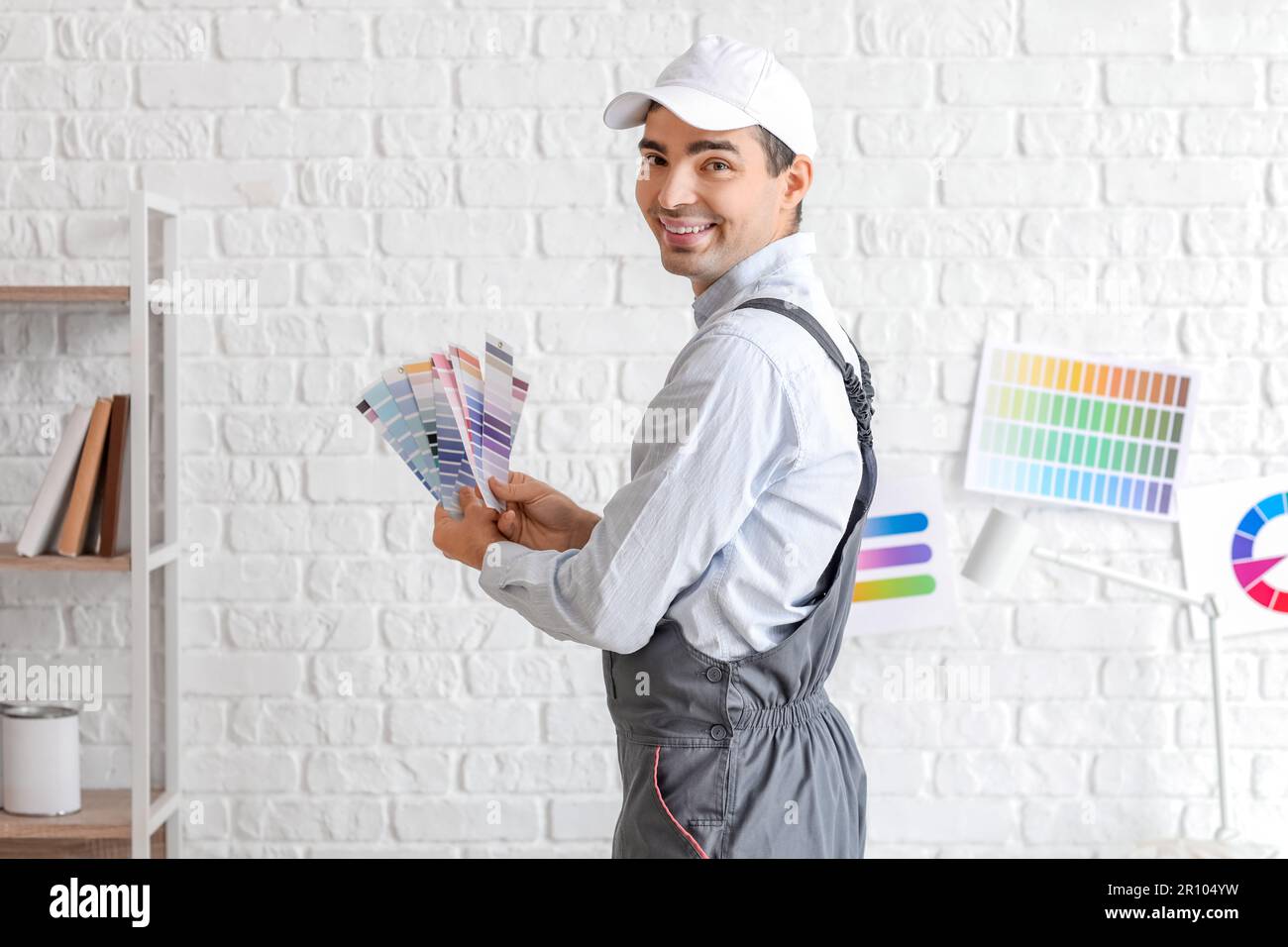 Male painter with color palettes near white brick wall Stock Photo Alamy