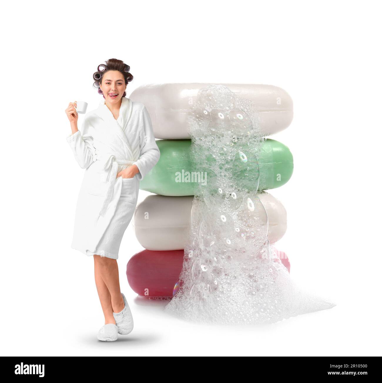 Beautiful young woman in bathrobe drinking coffee and stack of big soap