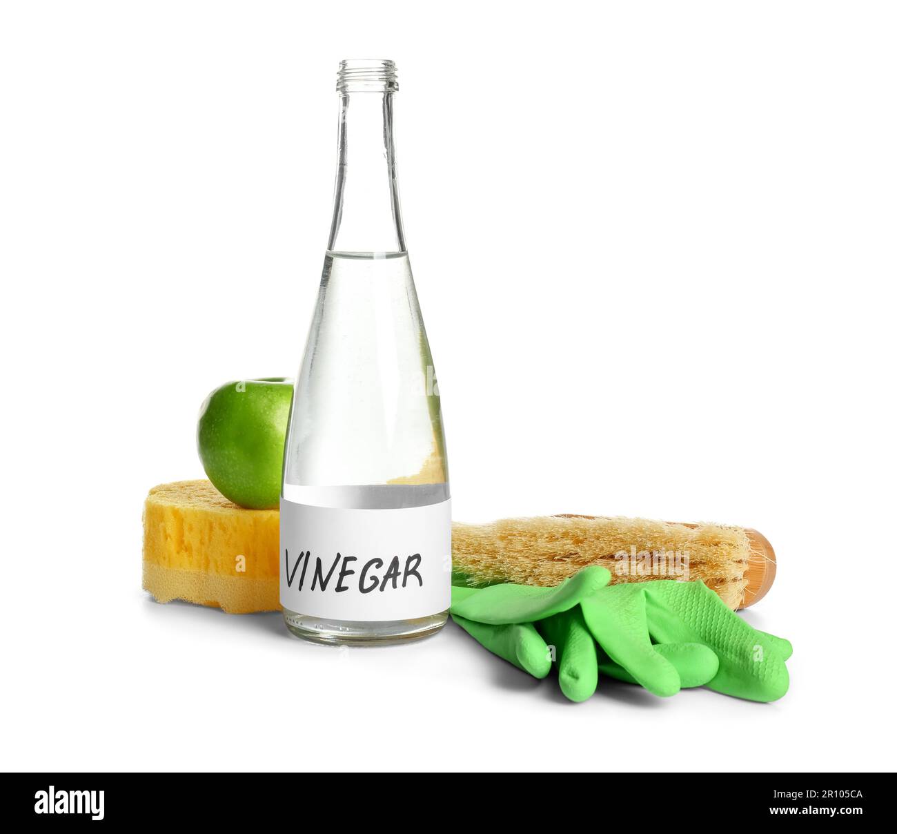 Bottle of vinegar, brush, sponge, rubber gloves and apple on white