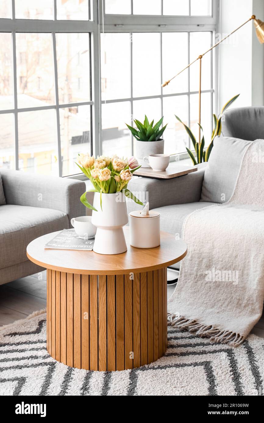 Interior of bright living room with cozy sofa and coffee table near big ...