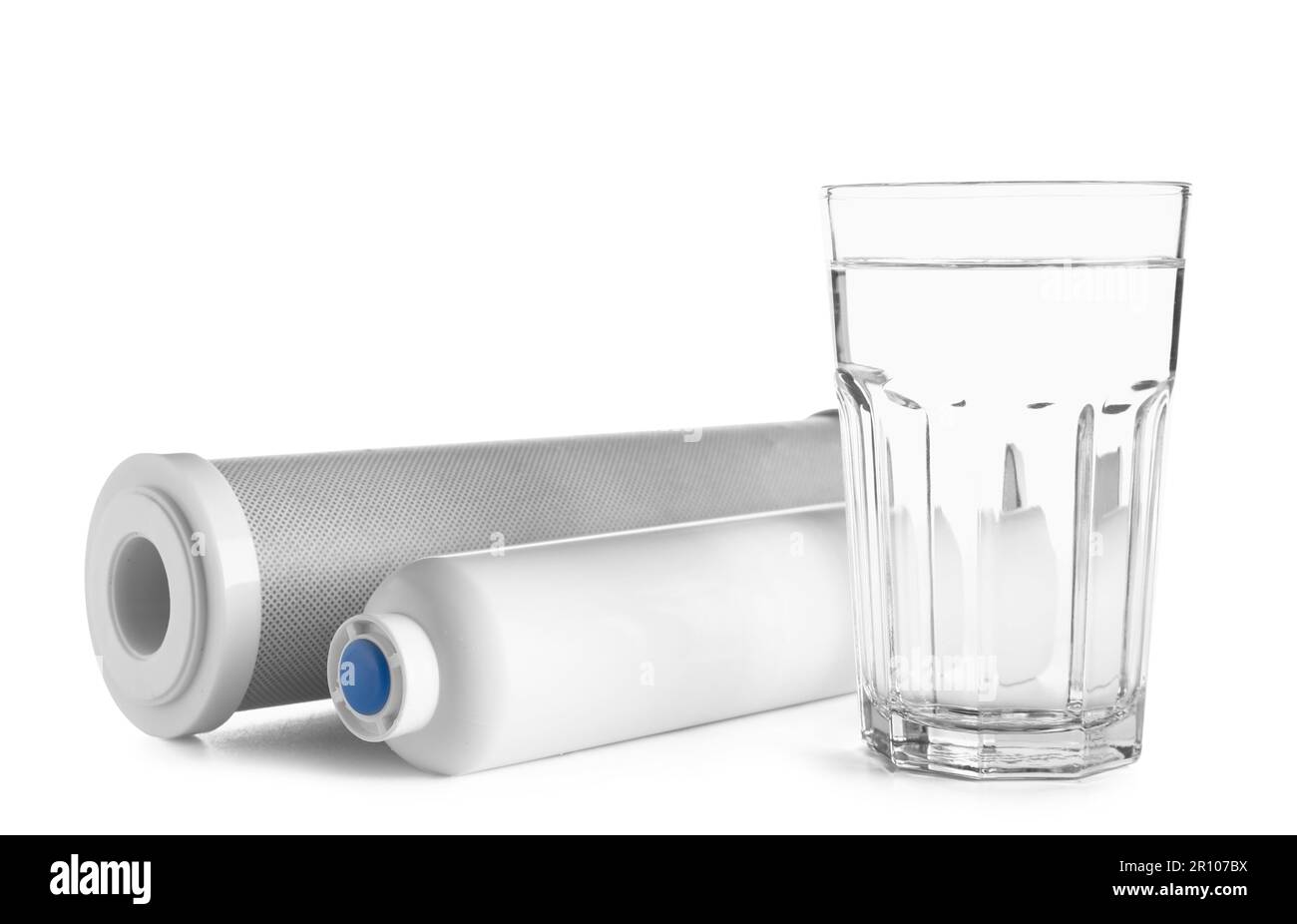Glass of liquid and water filter cartridges isolated on white