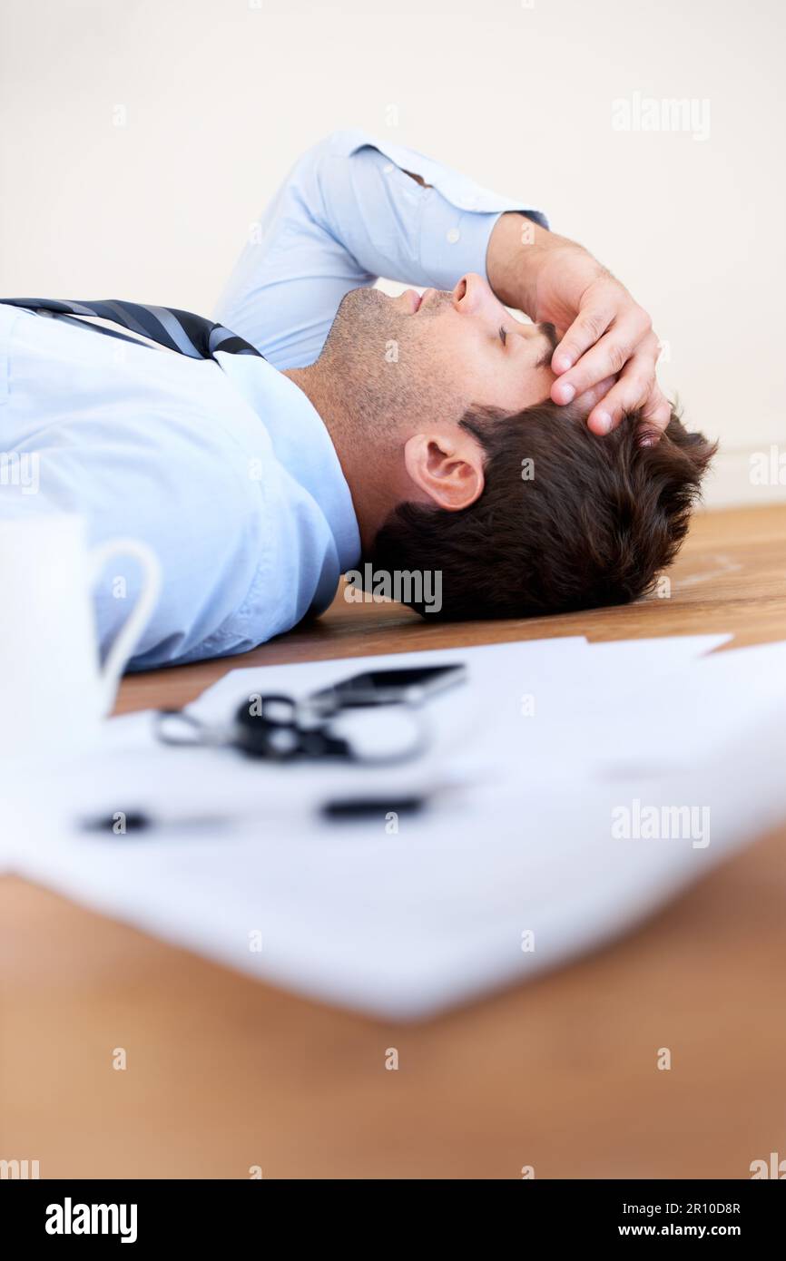 Hand Rested On Paper Hes had enough - business pressure. A businessman lying on the floor ...