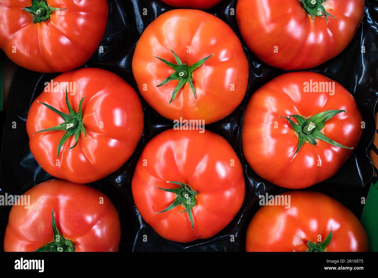 group of ripe red tomatoes in grocery produce Stock Photo