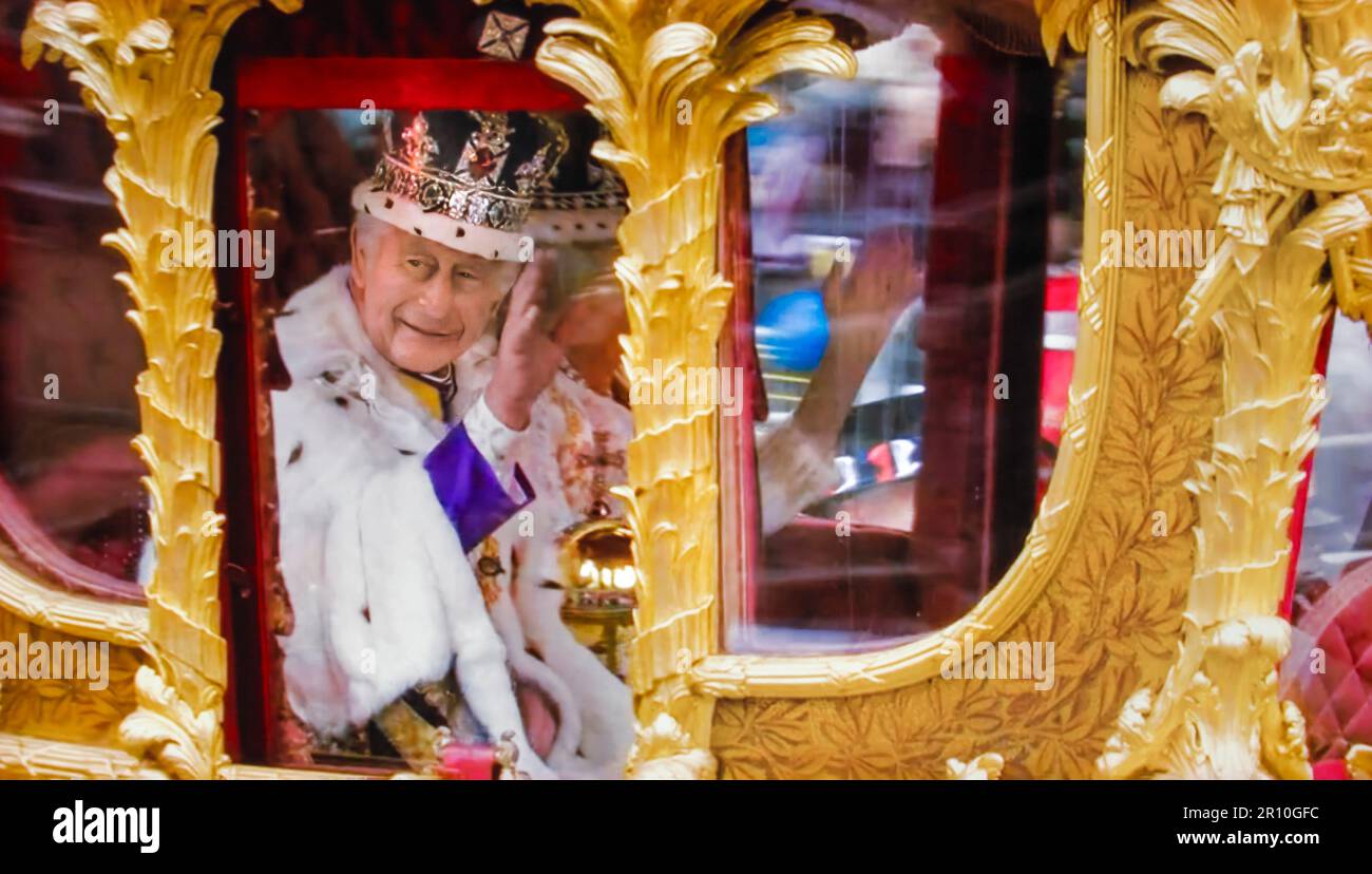 King Charles III and Queen Camilla traveling in Gold Coach wearing their crowns, wave to the crowds from the Golden State Coach after their joint Coronation at Westminster Abbey. Westminster London. May 06, 2023. This state coach has been used at the coronation of every British monarch since William IV. Stock Photo