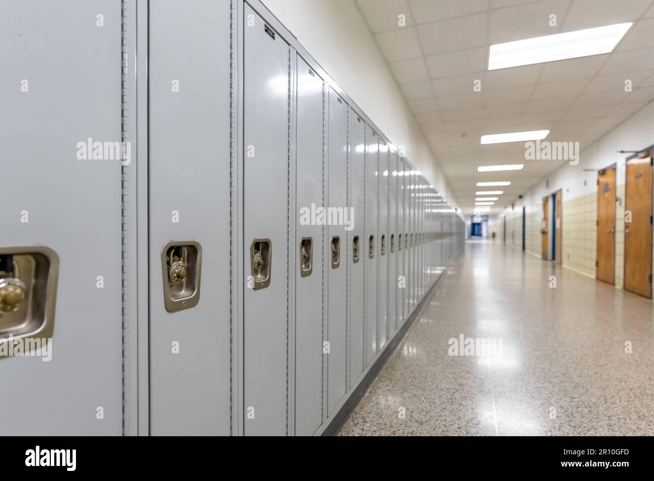 Empty middle school or high school hallway with gray student lockers Stock Photo