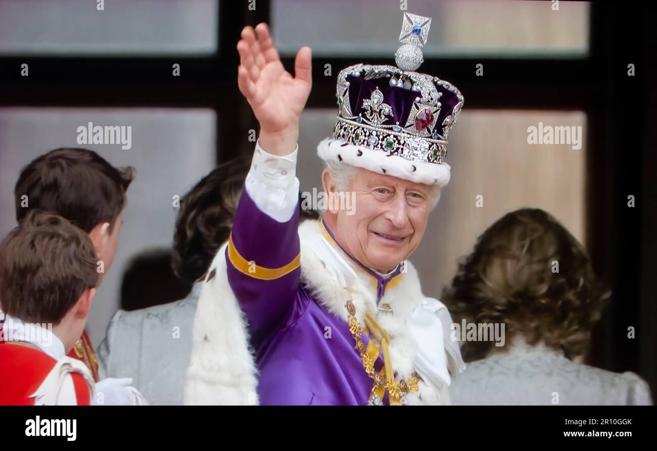 King Charles III waving from Balcony Buckingham Palace, wearing The Crown of State (The Imperial State Crown) and his coronation robes, waves a thank you to the crowds below, from the balcony of Buckingham Palace, after his and Queen Camilla's Coronation at Westminster Abbey Westminster London May 6th 2023 Stock Photo