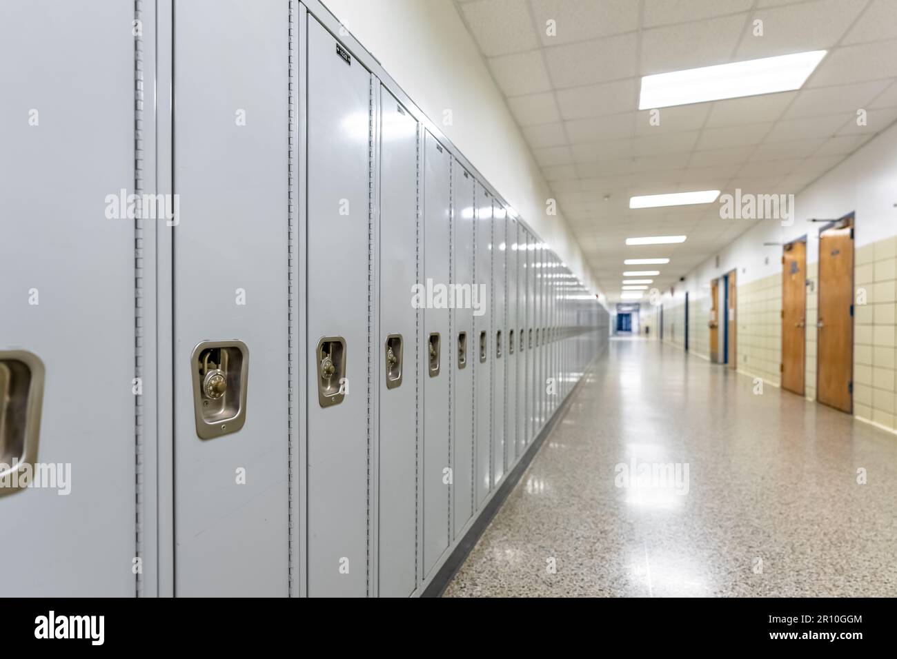 Empty middle school or high school hallway with gray student lockers Stock Photo