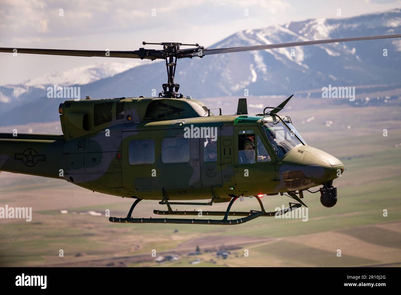 A 40th Helicopter Squadron UH-N1 Huey pilot glances at his counterpart midflight May 2, 2023, at Malmstrom Air Force Base, Mont. The 40th Helicopter Squadron, a tenant unit assigned to Malmstrom Air Force Base, Montana, began as Detachment 5 of the 37th Air Rescue and Recovery Squadron and was one of seven detachments in the 37th ARRS under Military Airlift Command.  The 37th ARRS was activated during the Korean War when helicopters were first used for medical evacuation. After the Vietnam War, 37th ARRS was deactivated, only to be reactivated in December 1973. (U.S. Air Force photo by Airman Stock Photo