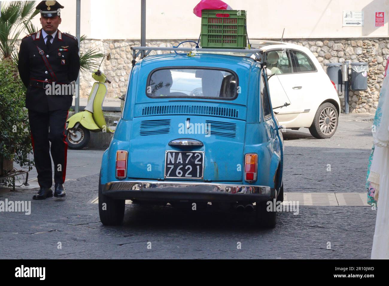 An original Fiat 500 Cinquecento has right of way at traffic controlled lights, to a current modern Fiat 500 3 door hatchback in Amalfi, Italy. Stock Photo