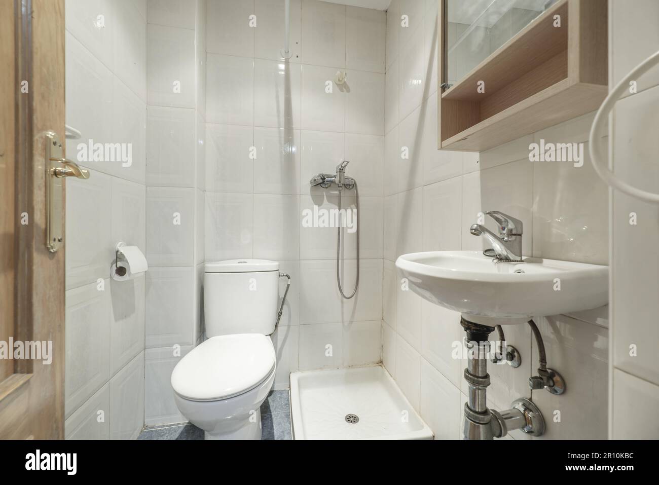 A simple toilet with a small shower tray, white porcelain toilets and a