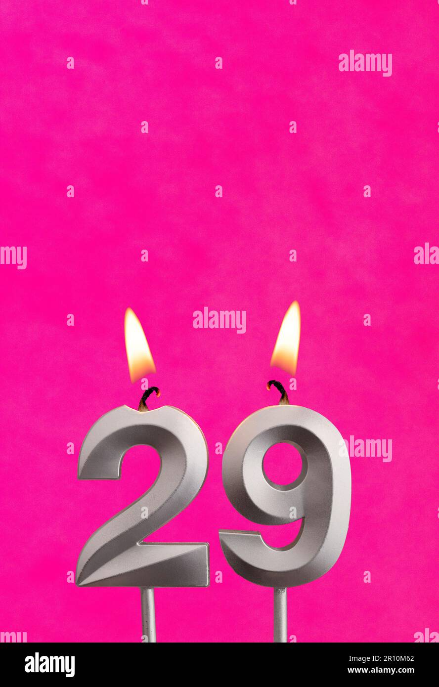 Number 29 candle - Birthday celebration on fuchsia background Stock Photo