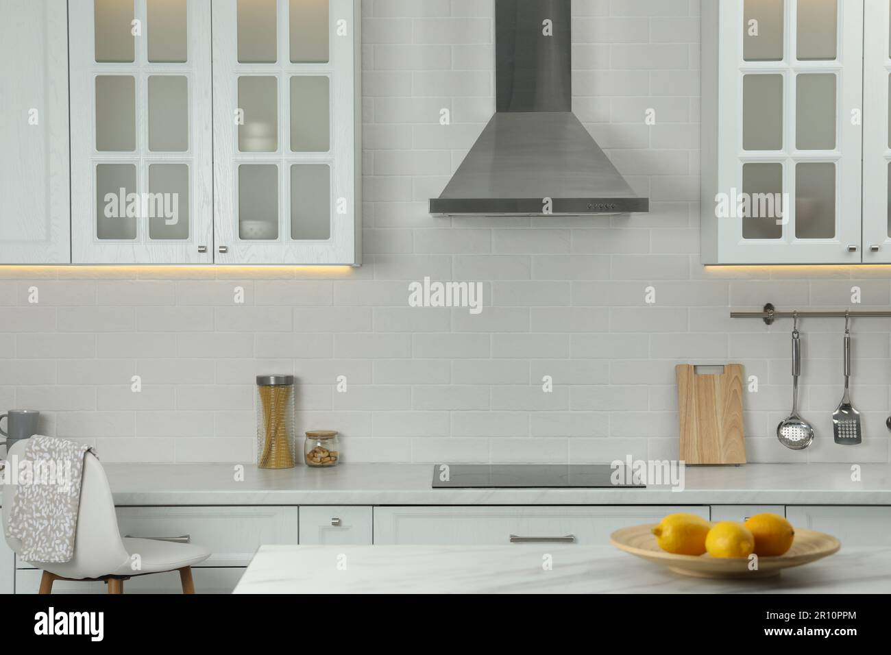 Elegant kitchen interior with modern range hood over cooktop and