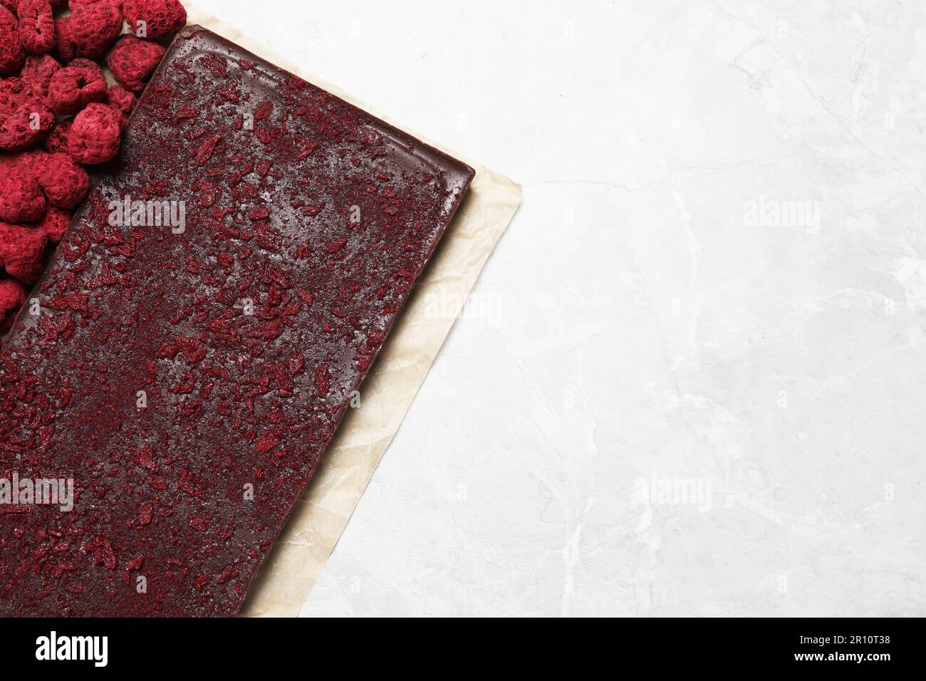 Chocolate bar with freeze dried raspberries on light marble table, top ...