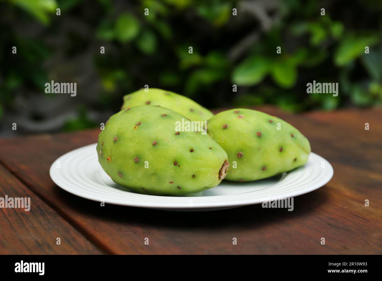 Tasty prickly pear fruits on wooden table outdoors Stock Photo