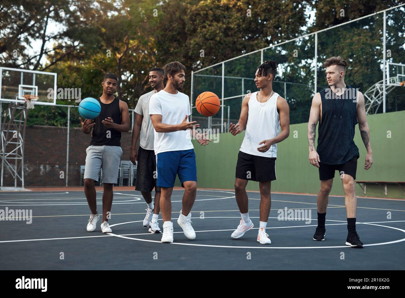 Lets shoot a couple of more hoops. a group of sporty young men hanging