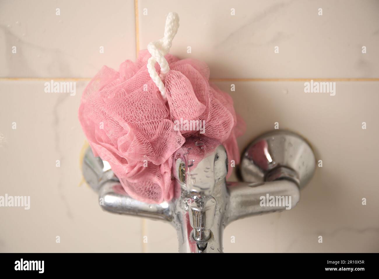 Pink shower puff on faucet in bathroom, closeup Stock Photo - Alamy