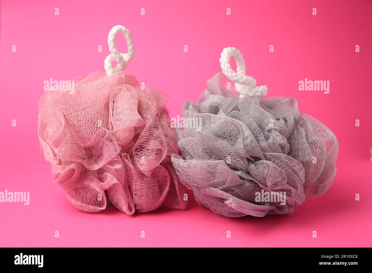 Colorful shower puffs on pink background. Personal hygiene Stock Photo