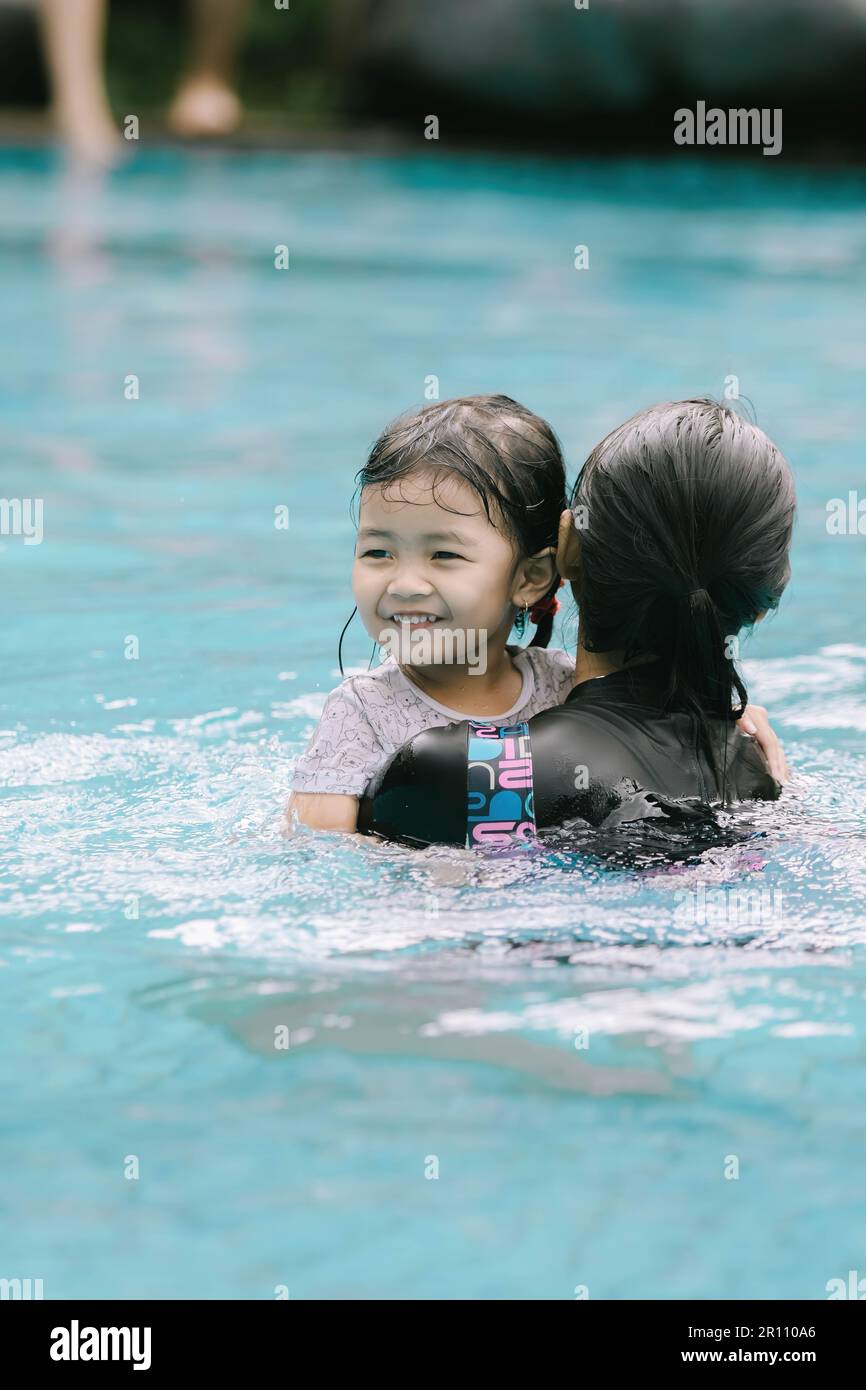 Portrait Or Vertical Shot Of A Young Southeast Asian Girl Is Carried By An Older Sister In The 