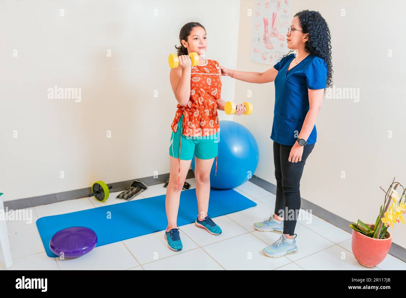 Rehabilitation Physiotherapy To Patient With Dumbbells. Female ...