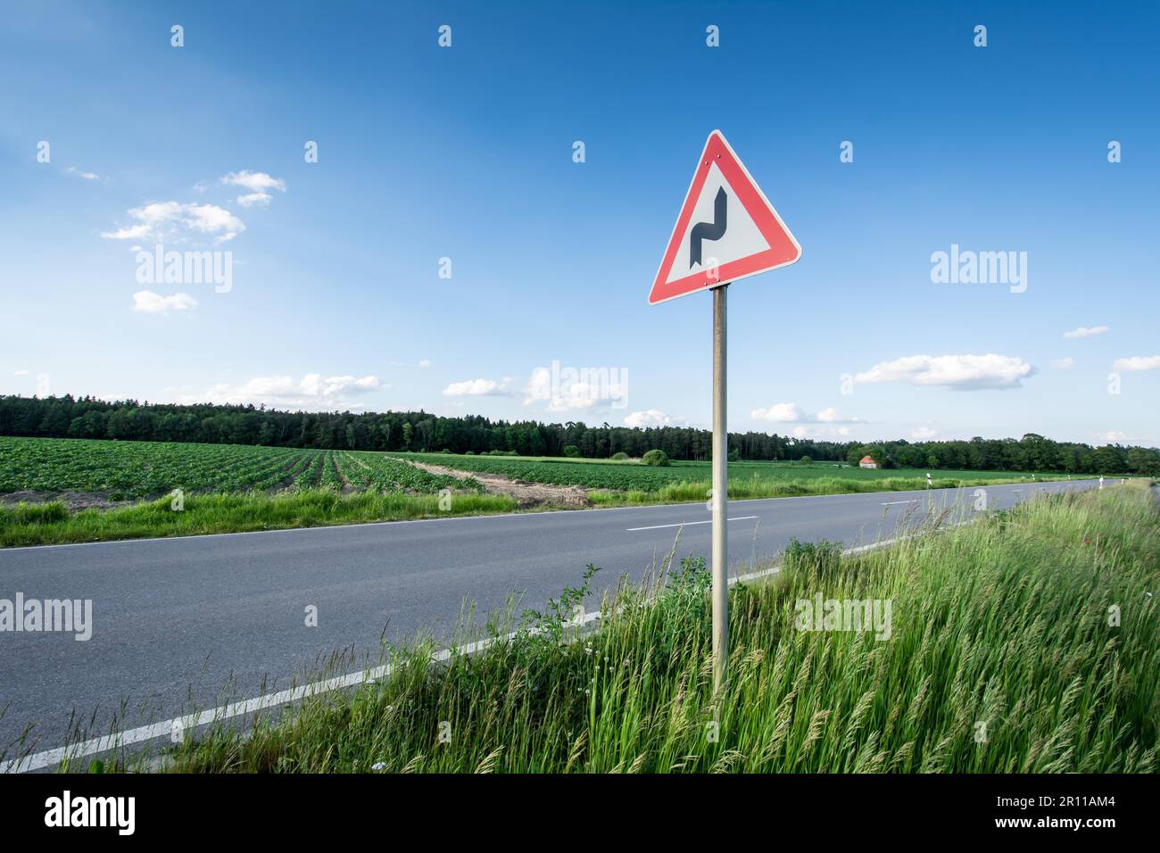 Traffic sign warning for a winding road Stock Photo