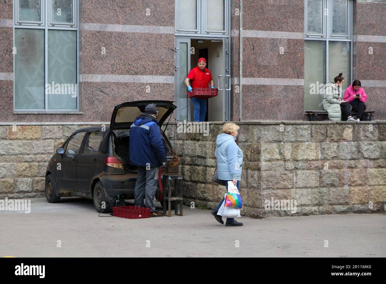 Saint Petersburg, Russia. 5th May, 2023. A man repairs a daewoo matiz car near a residential building on Komendantsky Prospekt, in Saint Petersburg. (Credit Image: © Maksim Konstantinov/SOPA Images via ZUMA Press Wire) EDITORIAL USAGE ONLY! Not for Commercial USAGE! Stock Photo