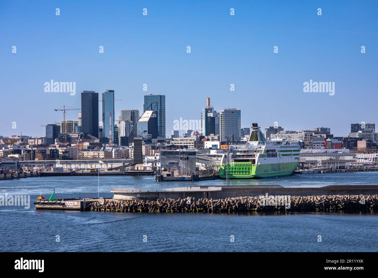 Breakwater, passenger harbor and high-rise buildings against clear blue sky viewed from the sea in Tallinn, Estonia Stock Photo